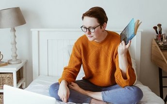 Osoba ucząca się na łóżku przed komputerem