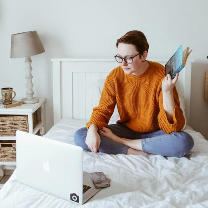Osoba ucząca się na łóżku przed komputerem